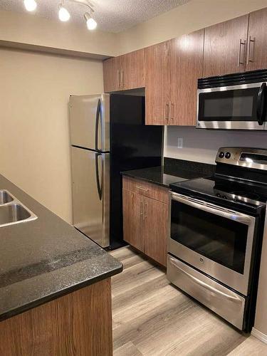 4312-403 Mackenzie Way Sw, Airdrie, AB - Indoor Photo Showing Kitchen With Stainless Steel Kitchen With Double Sink