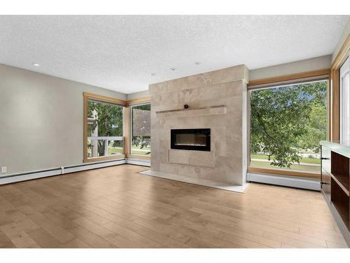 8-3422 Parkdale Boulevard Nw, Calgary, AB - Indoor Photo Showing Living Room With Fireplace