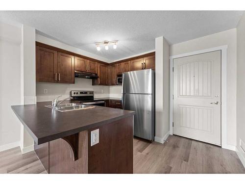 1216-130 Panatella Street Nw, Calgary, AB - Indoor Photo Showing Kitchen With Stainless Steel Kitchen With Double Sink