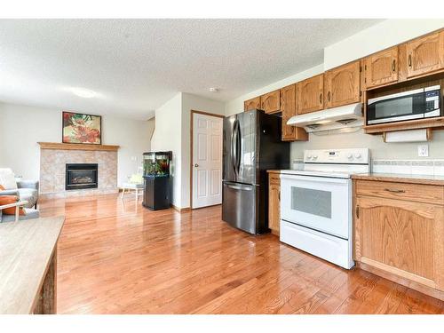 224 Arbour Stone Rise Nw, Calgary, AB - Indoor Photo Showing Kitchen With Fireplace