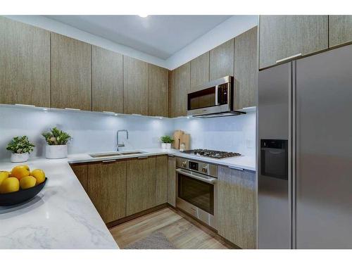 222-823 5 Avenue Nw, Calgary, AB - Indoor Photo Showing Kitchen With Stainless Steel Kitchen With Double Sink With Upgraded Kitchen