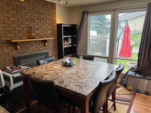 17 Mckernan Road Se, Calgary, AB - Indoor Photo Showing Dining Room With Fireplace