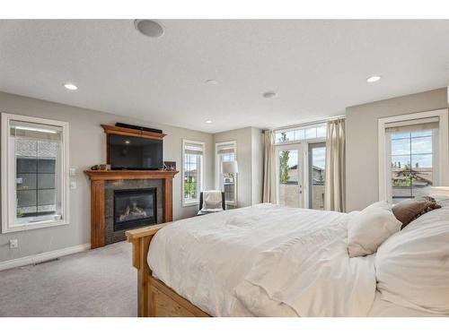 210 Montenaro Place, Rural Rocky View County, AB - Indoor Photo Showing Bedroom With Fireplace