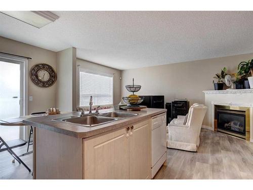 137 Bridleridge Circle Sw, Calgary, AB - Indoor Photo Showing Kitchen With Fireplace With Double Sink