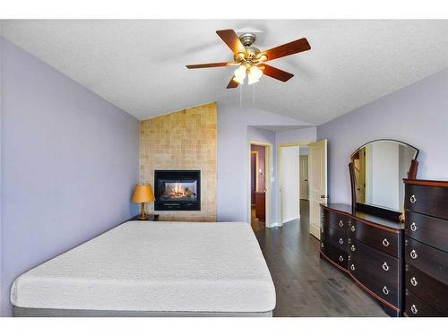 128 Tuscany Ravine Terrace Nw, Calgary, AB - Indoor Photo Showing Bedroom With Fireplace