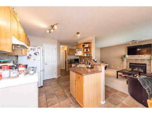 154 Bridlewood Court Sw, Calgary, AB - Indoor Photo Showing Kitchen With Fireplace