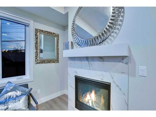 2-2633 1 Avenue Nw, Calgary, AB - Indoor Photo Showing Living Room With Fireplace