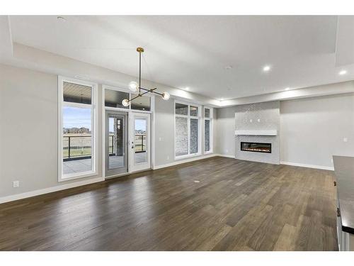 201-120 Marina Cove Se, Calgary, AB - Indoor Photo Showing Living Room With Fireplace