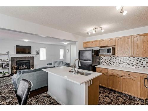 42 Evansford Grove Nw, Calgary, AB - Indoor Photo Showing Kitchen With Fireplace With Double Sink