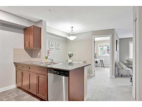 9110-403 Mackenzie Way Sw, Airdrie, AB - Indoor Photo Showing Kitchen With Double Sink