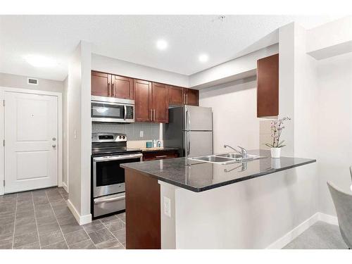 9110-403 Mackenzie Way Sw, Airdrie, AB - Indoor Photo Showing Kitchen With Double Sink