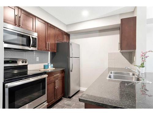 9110-403 Mackenzie Way Sw, Airdrie, AB - Indoor Photo Showing Kitchen With Double Sink