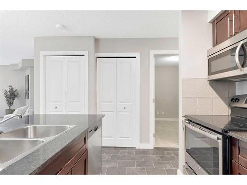 9110-403 Mackenzie Way Sw, Airdrie, AB - Indoor Photo Showing Kitchen With Double Sink