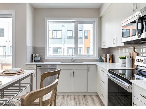 106-1453 Na'A Drive Sw, Calgary, AB - Indoor Photo Showing Kitchen With Double Sink