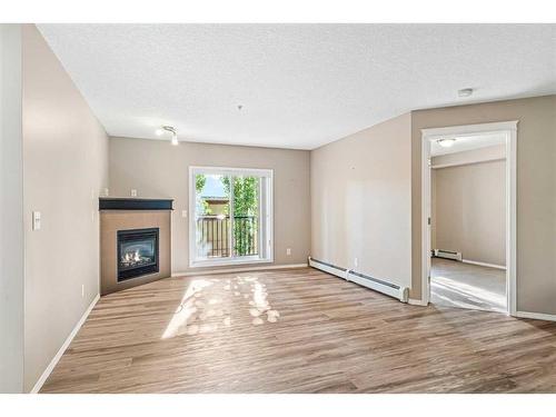 206-6315 Ranchview Drive Nw, Calgary, AB - Indoor Photo Showing Living Room With Fireplace