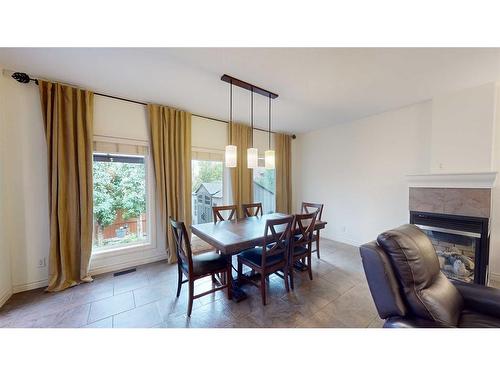 243 Chaparral Ravine View Se, Calgary, AB - Indoor Photo Showing Dining Room With Fireplace