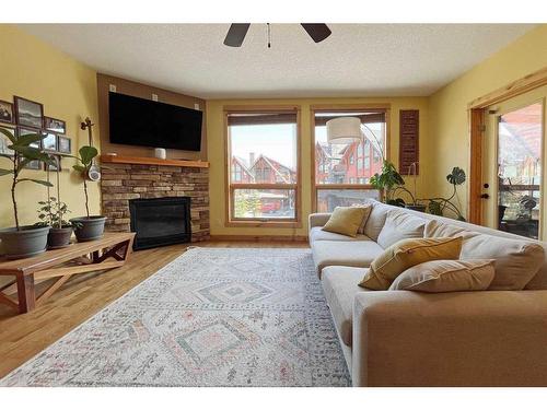 201-2100B Stewart Creek Drive, Canmore, AB - Indoor Photo Showing Living Room With Fireplace