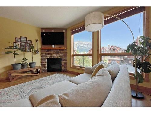 201-2100B Stewart Creek Drive, Canmore, AB - Indoor Photo Showing Living Room With Fireplace