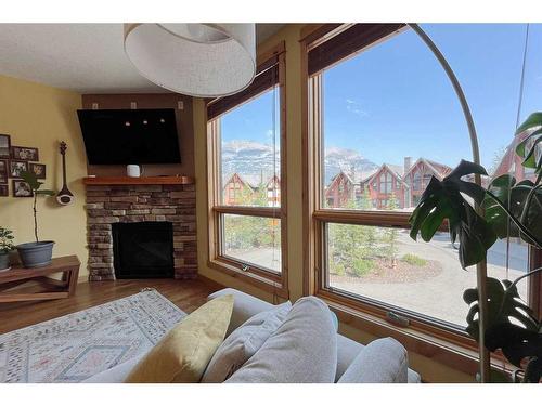 201-2100B Stewart Creek Drive, Canmore, AB - Indoor Photo Showing Living Room With Fireplace