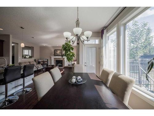 87 Silverado Skies Drive Sw, Calgary, AB - Indoor Photo Showing Dining Room With Fireplace