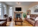 344 Willow Ridge Manor, Diamond Valley, AB  - Indoor Photo Showing Living Room With Fireplace 