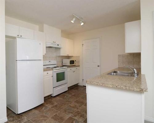 206-1010 Railway Street, Crossfield, AB - Indoor Photo Showing Kitchen With Double Sink