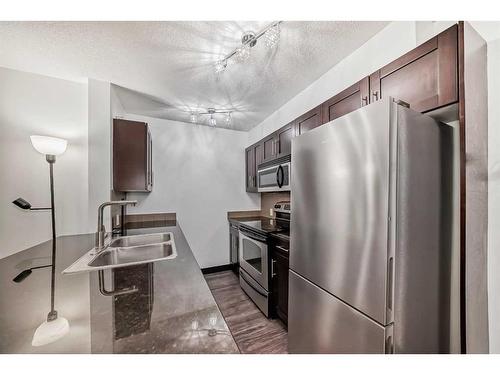 2111-403 Mackenzie Way Sw, Airdrie, AB - Indoor Photo Showing Kitchen With Stainless Steel Kitchen With Double Sink