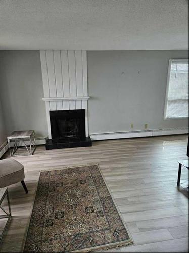 202-219 Huntington Park Bay Nw, Calgary, AB - Indoor Photo Showing Living Room With Fireplace