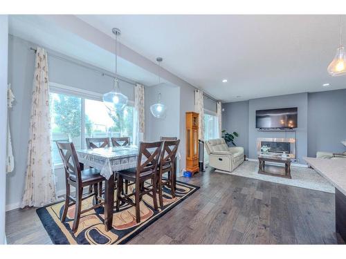 52 Cooperstown Place Sw, Airdrie, AB - Indoor Photo Showing Dining Room With Fireplace