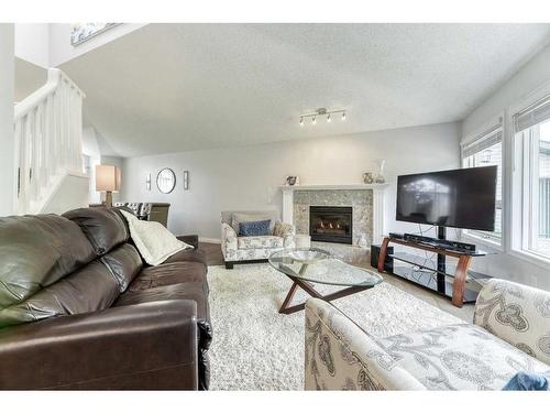 81 Gleneagles Close, Cochrane, AB - Indoor Photo Showing Living Room With Fireplace