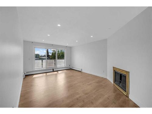 213-335 Garry Crescent Ne, Calgary, AB - Indoor Photo Showing Living Room With Fireplace