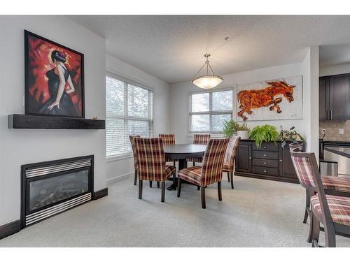 206-88 Arbour Lake Road Nw, Calgary, AB - Indoor Photo Showing Dining Room With Fireplace