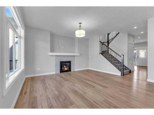 109 Kinniburgh Cove, Chestermere, AB - Indoor Photo Showing Other Room With Fireplace