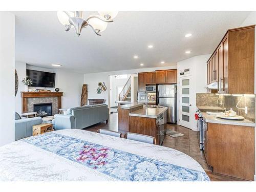 143 New Brighton Close Se, Calgary, AB - Indoor Photo Showing Kitchen With Fireplace