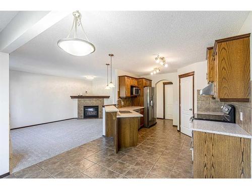 48 Eversyde Manor Sw, Calgary, AB - Indoor Photo Showing Kitchen With Fireplace