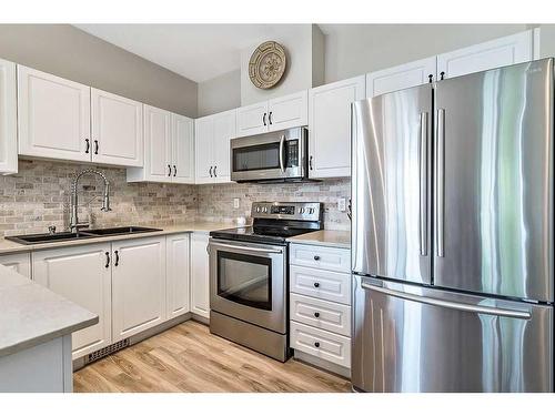 201-16 Poplar Avenue, Okotoks, AB - Indoor Photo Showing Kitchen With Double Sink With Upgraded Kitchen