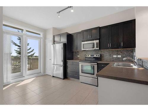 1412-125 Panatella Way Nw, Calgary, AB - Indoor Photo Showing Kitchen With Stainless Steel Kitchen With Double Sink