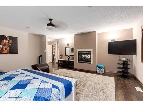 6 Rockcliff Landing Nw, Calgary, AB - Indoor Photo Showing Bedroom With Fireplace