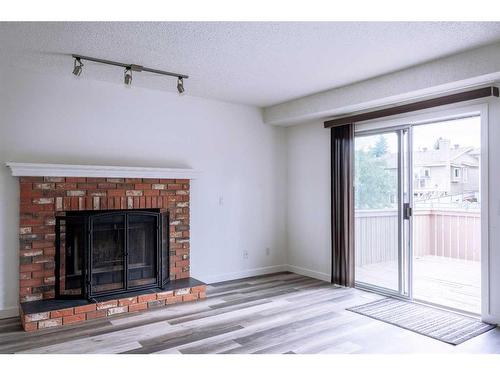 85 Shawinigan Drive Sw, Calgary, AB - Indoor Photo Showing Living Room With Fireplace