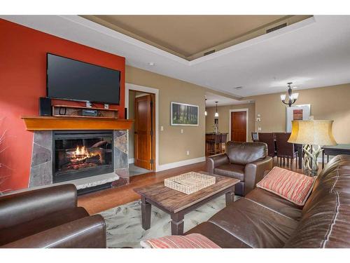 107Bf-187 Kananaskis Way, Canmore, AB - Indoor Photo Showing Living Room With Fireplace