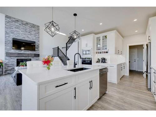 235 Precedence Hill, Cochrane, AB - Indoor Photo Showing Kitchen With Fireplace