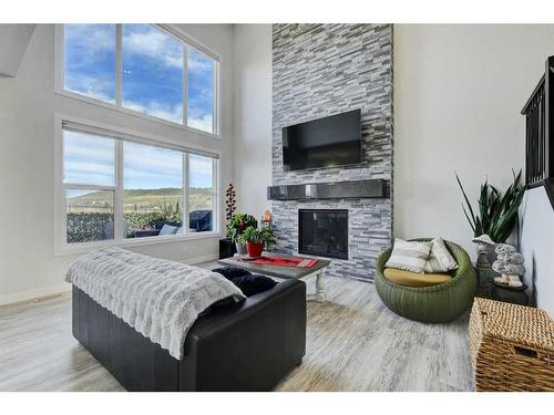 235 Precedence Hill, Cochrane, AB - Indoor Photo Showing Living Room With Fireplace