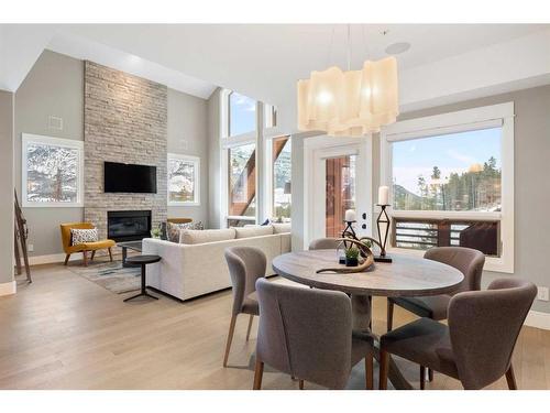 201-2100E Stewart Creek Drive, Canmore, AB - Indoor Photo Showing Dining Room With Fireplace