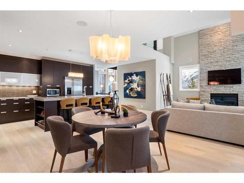 201-2100E Stewart Creek Drive, Canmore, AB - Indoor Photo Showing Dining Room With Fireplace