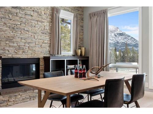 201-2100E Stewart Creek Drive, Canmore, AB - Indoor Photo Showing Dining Room With Fireplace