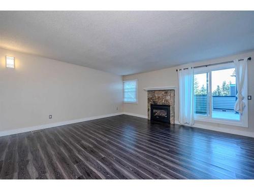 217-36 Glamis Green Sw, Calgary, AB - Indoor Photo Showing Living Room With Fireplace