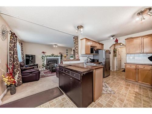 241 Covewood Circle Ne, Calgary, AB - Indoor Photo Showing Kitchen With Fireplace With Double Sink