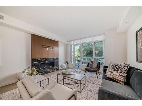 201-128 Waterfront Court Sw, Calgary, AB - Indoor Photo Showing Living Room With Fireplace