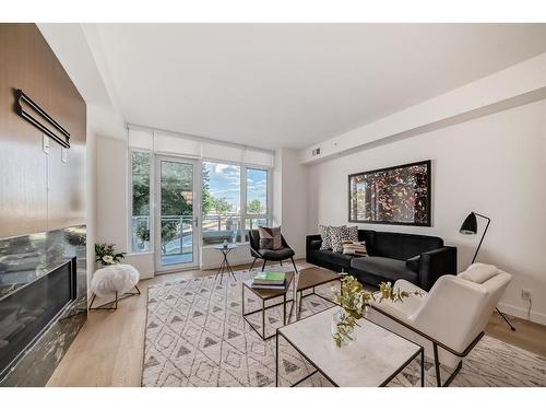 201-128 Waterfront Court Sw, Calgary, AB - Indoor Photo Showing Living Room With Fireplace