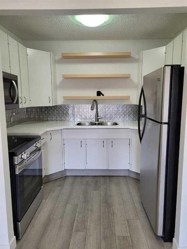 218-1616 8 Avenue Nw, Calgary, AB - Indoor Photo Showing Kitchen With Stainless Steel Kitchen With Double Sink